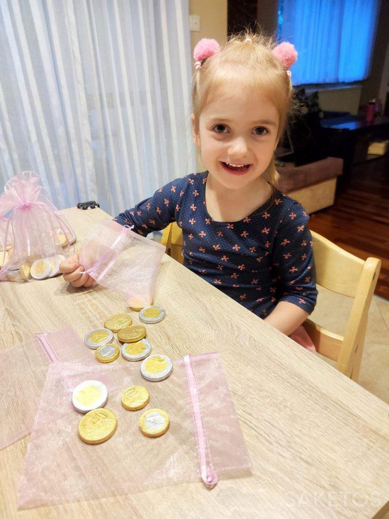 Ein Mädchen füllt Organzasäckchen mit Schokoladenmünzen