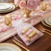 Organzabeutel gefüllt mit Süßigkeiten auf einem Hochzeitstisch.