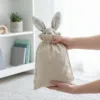 Leinenbeutel mit einem süßen Plüschhasen darin.