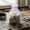 Organzabeutel 15x20 cm gefüllt mit Holzstempeln für Bastelarbeiten auf einem Werkstatttisch.