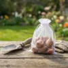 Weißer Organzabeutel zur Aufbewahrung von Blumenzwiebeln im Garten.