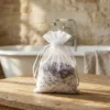 Organzabeutel mit getrocknetem Lavendel und Badesalz neben Wellness-Zubehör.