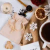 Jutesäckchen auf winterlich dekoriertem Tisch mit Teeblättern und Schneeflocken