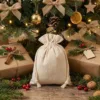 Leinen Säckchen als Weihnachtsgeschenkverpackung unter dem Weihnachtsbaum mit Dekoration