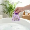 Organzasäckchen in der Hand über der Badewanne als dekoratives Badezimmer-Accessoire